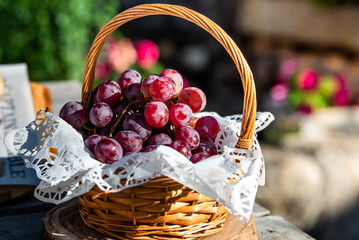 A wicker basket full of sweet red grapes at an event in a restaurant,