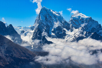 Dramatic twin peaks of Cholatse and Taboche against a bright blue sky seen from Gokyo Ri, Nepal