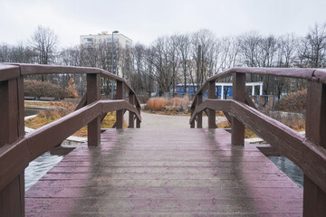 wooden bridge across a lake in an autumn park