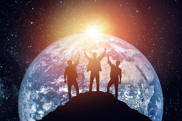 Silhouette of three people on the background of the planet, success concept. Elements of this image furnished by NASA - Powered by Adobe