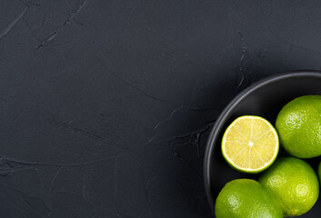 Lime fruit in black bowl closeup
