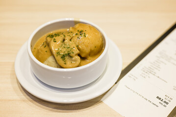 Mashed potato in white bowl served on the table with bill to pay