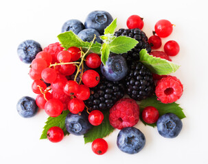 Various fresh berries isolated on white background. Raspberry, Blueberry, Cranberry, Blackberry and Mint leaves