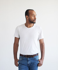 A young unshaven man on a light gray background. Mixed race handsome male model.