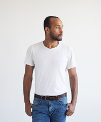 Fototapeta premium A young unshaven man on a light gray background. Mixed race handsome male model.