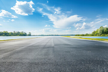Fototapeta premium Empty asphalt road near the lake under blue sky.