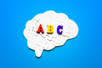Brain Shaped Puzzle with Colorful ABC Letters on Blue Background
