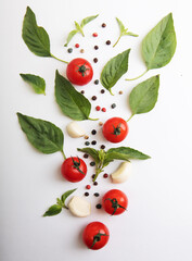 Ripe red tomatoes with basil, pepper and garlic isolated on white background. Top view.