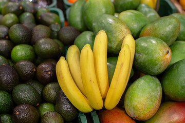 A branch of ripe bananas and avocados for sale in the store.
