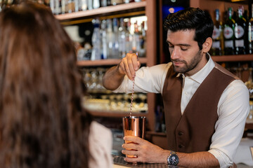 Man bartender is making a drink and dancing at bar. Dance party with group people dancing . Women and men have fun and drinking martini cocktail in night club.