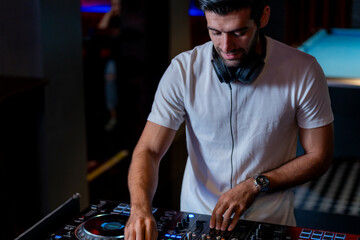 DJ musician man playing and mixing a song with a turntable and headphone. Dance party. excited dj...