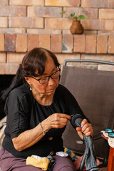 Yarn dreams: Elderly Asian woman's creative escape. Her Asian features stand out as she creates...