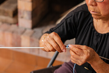 Artful aging. Asian woman knits with grace. A delightful elderly woman enjoys her retirement,...