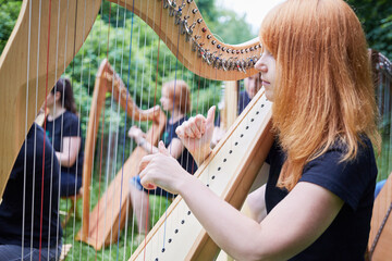 Musicians play harps outdoors in park
