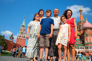 Family photo on red square on background of Kremlin and St. Basils Cathedral