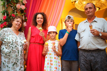 Happy family with ice cream posing in front of camera in shopping center