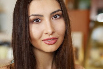 Young beautiful asian woman with long hair poses in cafe, close up