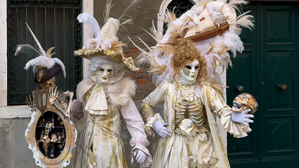 Venice Carnival. People in Venetian carnival masks and costumes on streets of Venice, Italy, Europe...