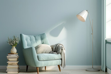 A tranquil corner featuring a pastel blue armchair with a soft blanket, beside a pile of books and a modern standing lamp.