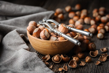 Vintage silver nutcracker on an aged wooden table, used to crack open hazelnuts, captured in a food photography composition