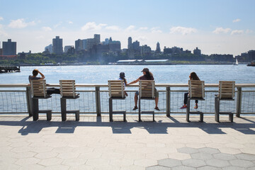  People sit on chairs and admire the views of the Brooklyn side of Manhattan