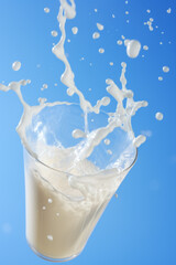 Dynamic Milk Splash in Glass on Blue Background