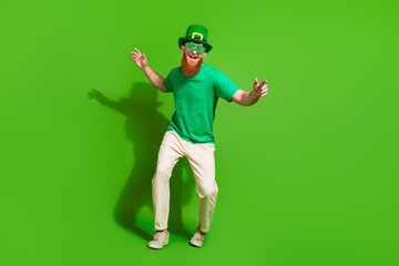Full body photo of positive overjoyed guy enjoy dancing st patrick occasion isolated on green color background