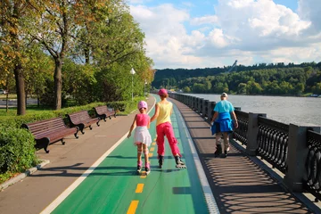 Fotobehang Mother with son and daughter ride on roller skates on luzhnetskaya quay river Moscow © Pavel Losevsky