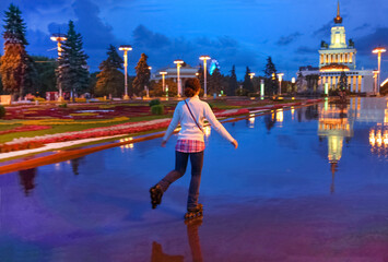 Young woman on roller skates on a summer evening in park