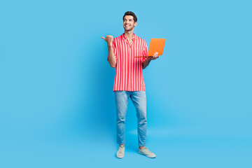 Full size photo of smart man dressed striped shirt hold laptop look directing at offer empty space isolated on blue color background