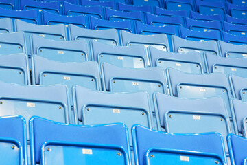 Rows of blue empty seats with numbers in big modern sport stadium