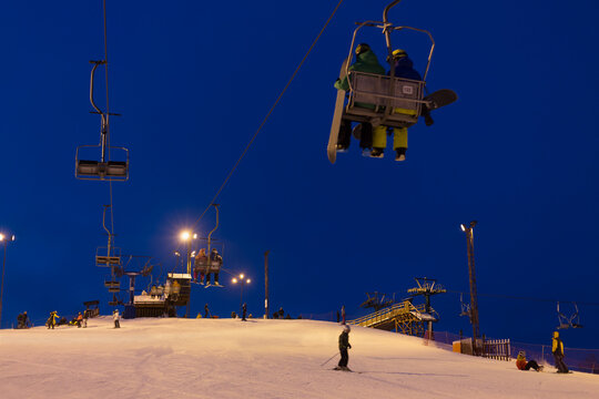Cableway above snowy slope at ski resort in evening time
