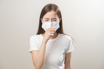 Unhealthy sickness, unwell asian young woman wearing mask coughing, have sore throat, suffering symptom cough feeling bad and healthcare of air pollution and dust, PM2.5 isolated white background.