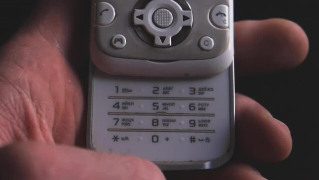 A man usiA man using retro mobile phone, device close upng retro mobile phone, device close up