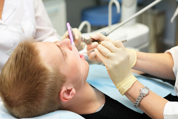Young male patient makes professional dental treatment in dental office