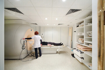 Unidentified doctor shows magnetic resonance exam procedure in hospital