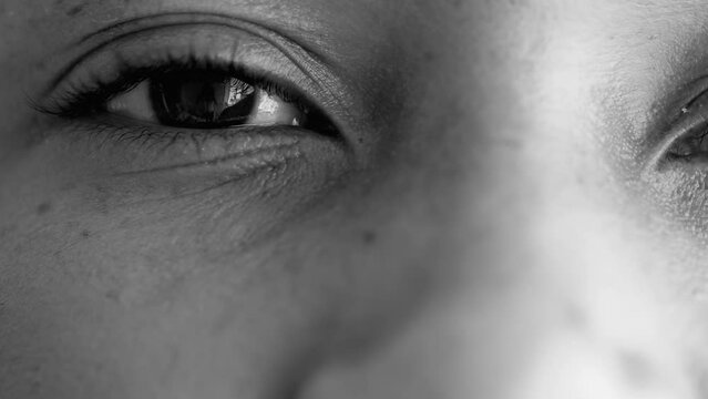 Macro Close-Up of one Young Black Woman's Eyes, Facial Detail of 20s Person with Neutral Gaze at Camera in monochrome, black and white