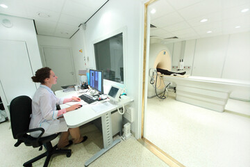 Doctor in control room, and magnetic resonance imaging machine with patient