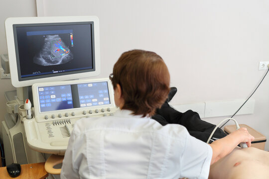  Doctor examines patient using ultrasound, in multidisciplinary clinic CELT, back view