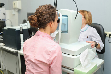 Doctor looking patients eye with an instrument exploring vessels of retina, Auto-Ref-Keratometer