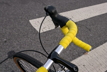 bike handlebar detail with bright yellow bar tape (bicycle cockpit, cycling) integrated shifters,...