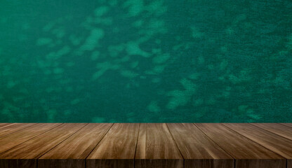empty wood table at foreground with dark green color fabric wallpaper at background with branch and...