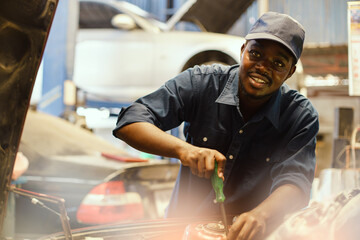 African auto mechanic inspects a car that has a problem with overheating causing smoke