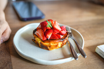 Close up delicious strawberry cheesecake in plate on wooden table.