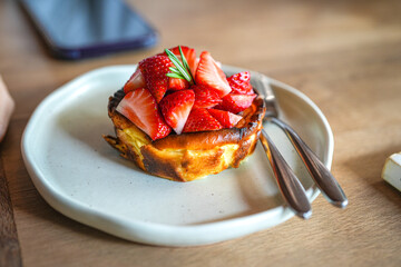 Close up delicious strawberry cheesecake in plate on wooden table.