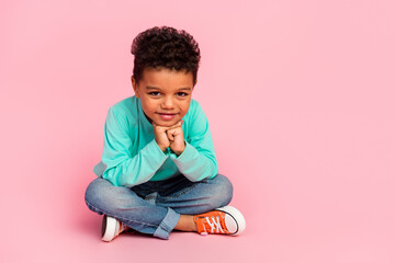 Full size photo of charming small boy sit floor look minded camera wear trendy aquamarine outfit isolated on pink color background