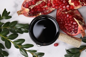Tasty pomegranate sauce, fruits and branches on white table, flat lay