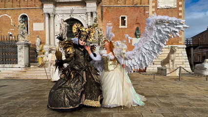 Venice Carnival. People in Venetian carnival masks and costumes on streets of Venice, Italy, Europe...