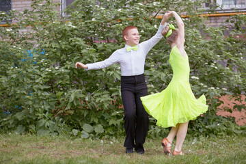 Little boy and girl dance ballroom dance outdoor at grassy lawn