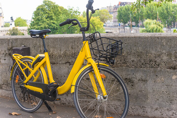 Fototapeta premium Yellow bicycle on parisian street by summer day